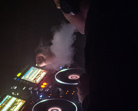 DJ vaping and mixing music in the dark